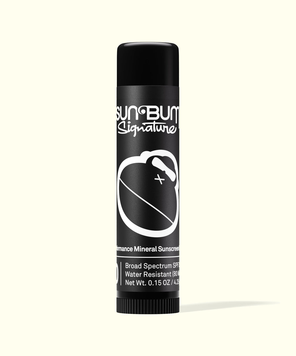 Sun Bum Signature lip balm with black packaging featuring white logo and text against a light background